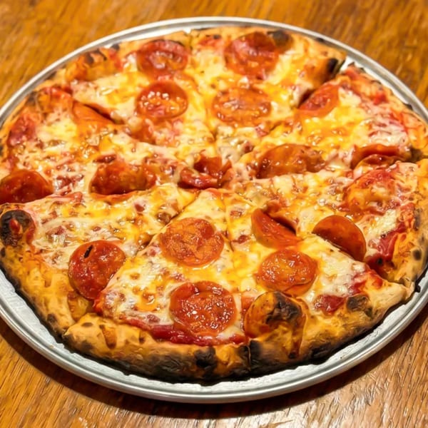 A whole pepperoni pizza with melted cheese and a crispy crust, served on a metal pan.