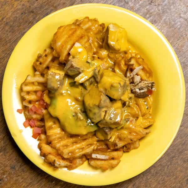 Murray's Deli waffle fries topped with cheese sauce, meat, and diced red peppers.